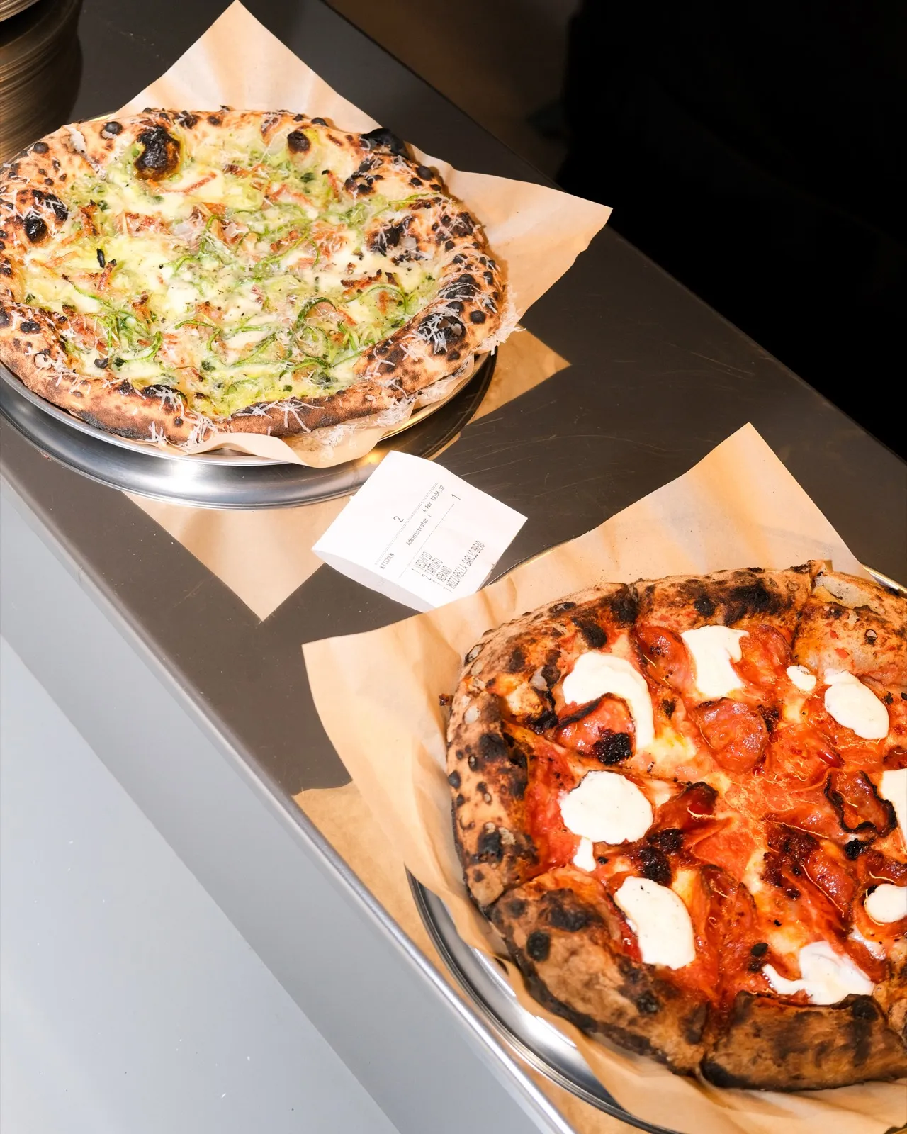 Two Neapolitan pizzas fresh from the oven at Filomena in Larnaca, with the leopard-spotted cornicione of a 48-hour biga dough