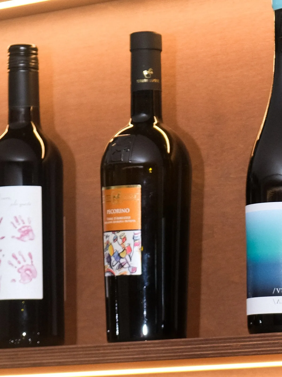 A bottle of Tenuta Ulisse Pecorino on the lit shelf at Filomena in Larnaca